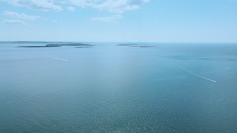 distant view of the boats sailing on the blue ocean of asa beach in southern gothenburg, halland, sweden. aerial