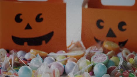 Grunge-textured-effect-over-halloween-candies-and-scary-pumpkin-printed-bags-on-white-background