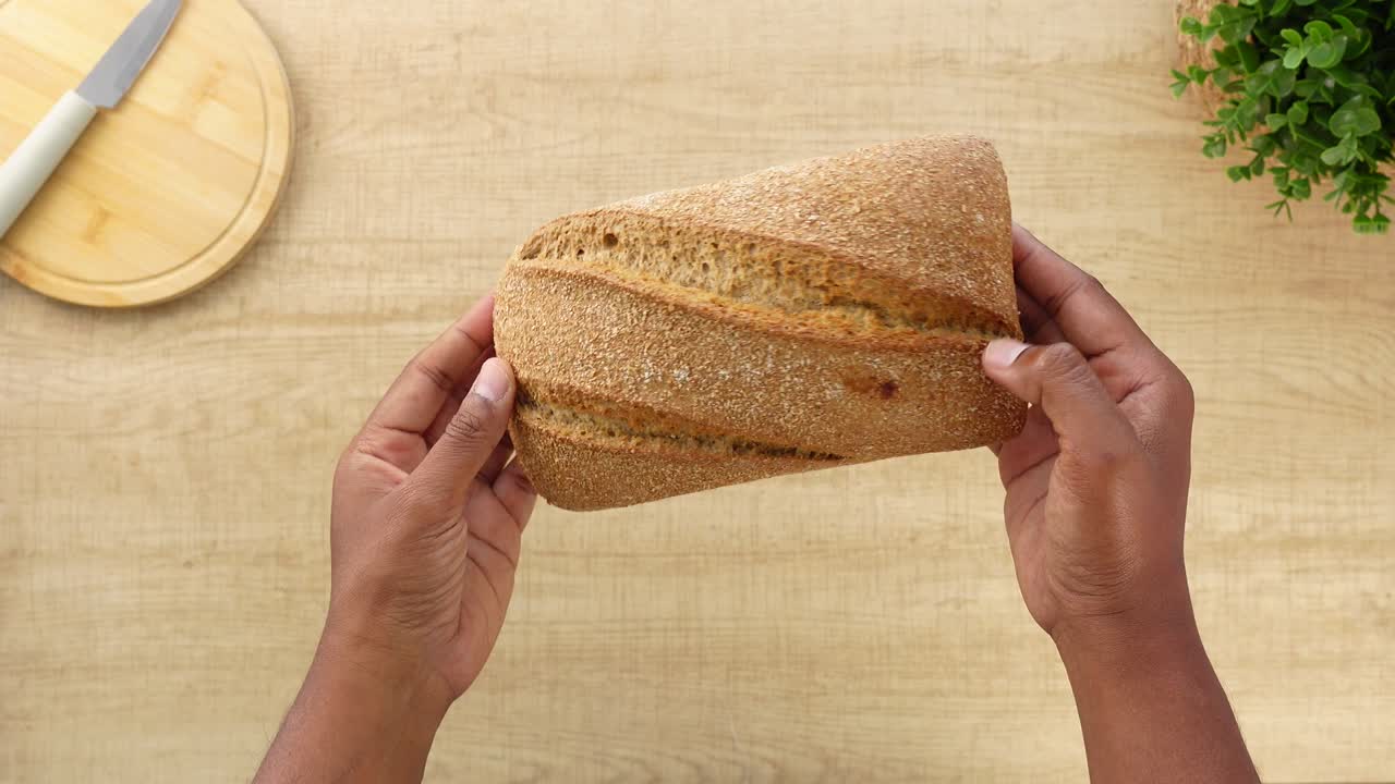 Hands holding a loaf of bread