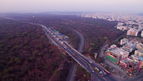suchitra circle with urban forest and railway track at suchitra, hyderabad, telangana, india. day time, push in, drone shot, 4k.