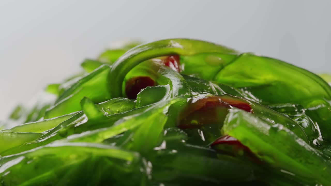 Japanese wakame chuka fermented food. Close-up on a detail of Hiyashi Wakame Chuka or seaweed salad or seaweed with sesame seeds on a plate. Top view. Seafood background. Health concept.