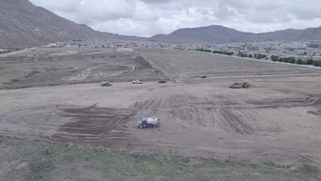 un avión no tripulado captura la escena cuando un camión de agua reinicia su rotación mientras completa metódicamente el vertido de agua para preparar un nuevo lote para la futura construcción de viviendas