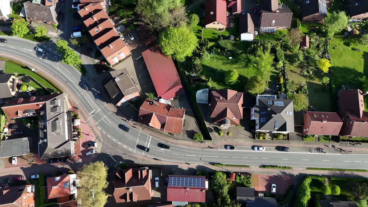 Cars on curvy street during sunny in American town. Sunny day in spring. Aerial top down flyover. Red roof townhouses in USA.