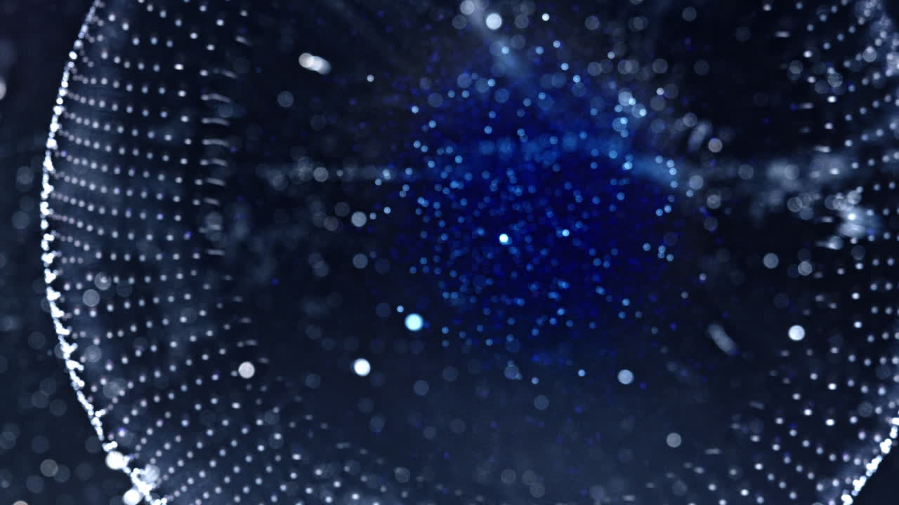 Abstract macro view of swirling alcoholic ink with glowing blue particles