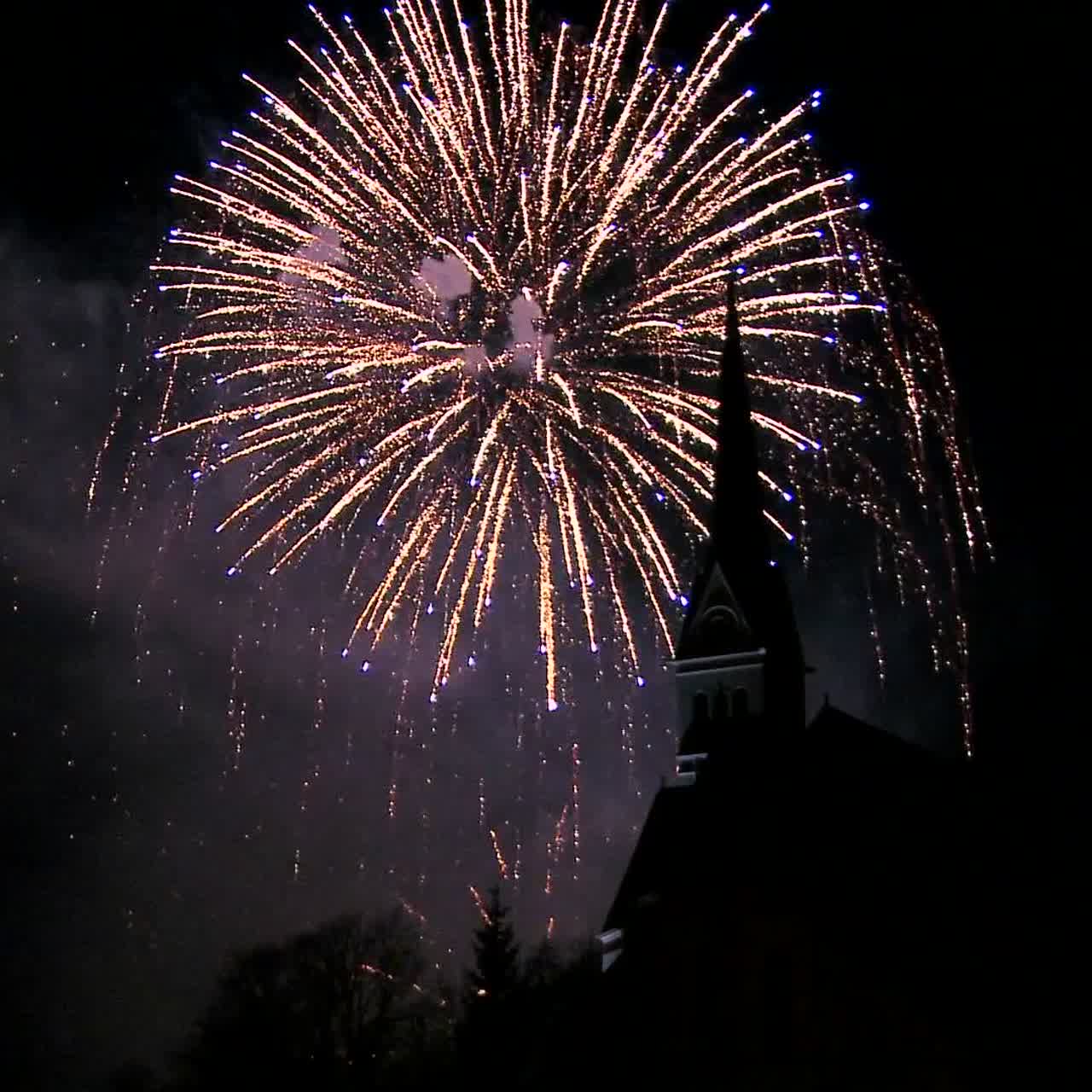 un magnífico espectáculo de fuegos artificiales detrás de una iglesia