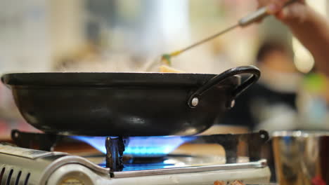 revolviendo un plato en la cocina de gas