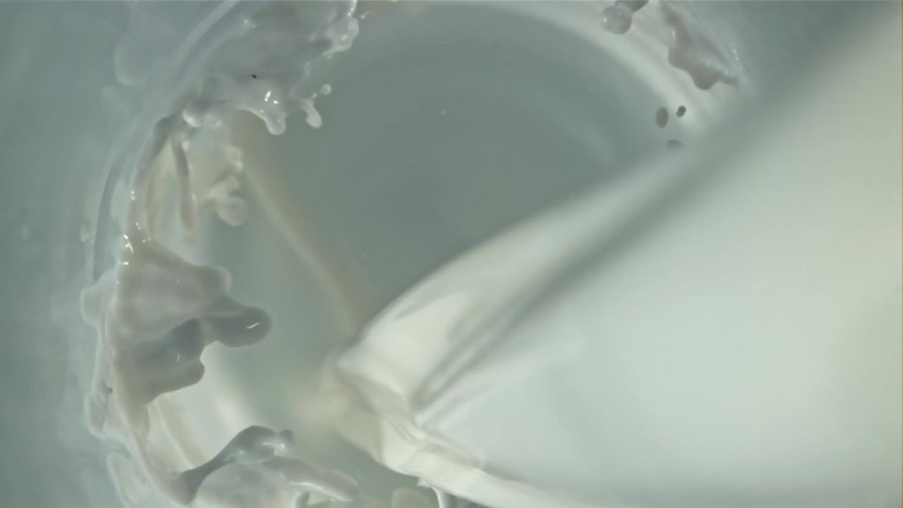 Milk Pouring and Splashing Inside a Glass in Slow Motion