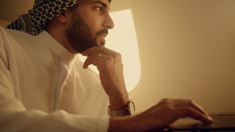Business-owner-typing-laptop-on-trip-closeup.-Thinking-arabian-writing-email