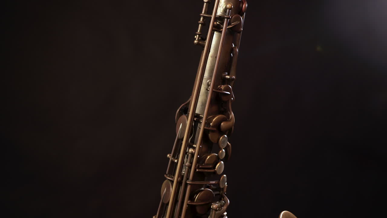 Tilt up and down shot of vintage sax on stand, dark background
