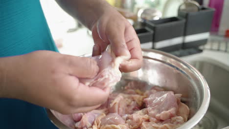 Close-up-of-man's-hands-peeling-raw-chicken