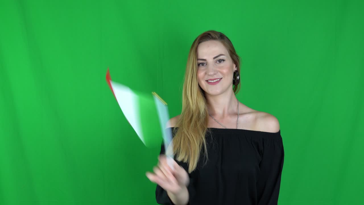 mujer rubia agitando delante de la bandera de italia pantalla verde, fondo clave de croma