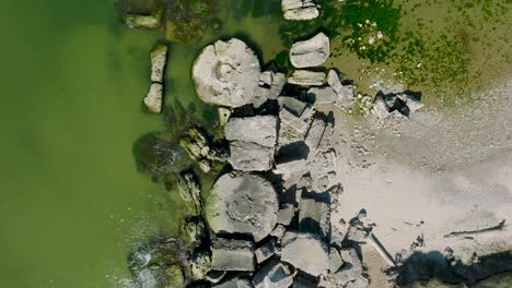 Beautiful-aerial-establishing-view-of-Karosta-concrete-coast-fortification-ruins,-calm-Baltic-sea,-sunny-summer-day,-birdseye-drone-shot-moving-forward