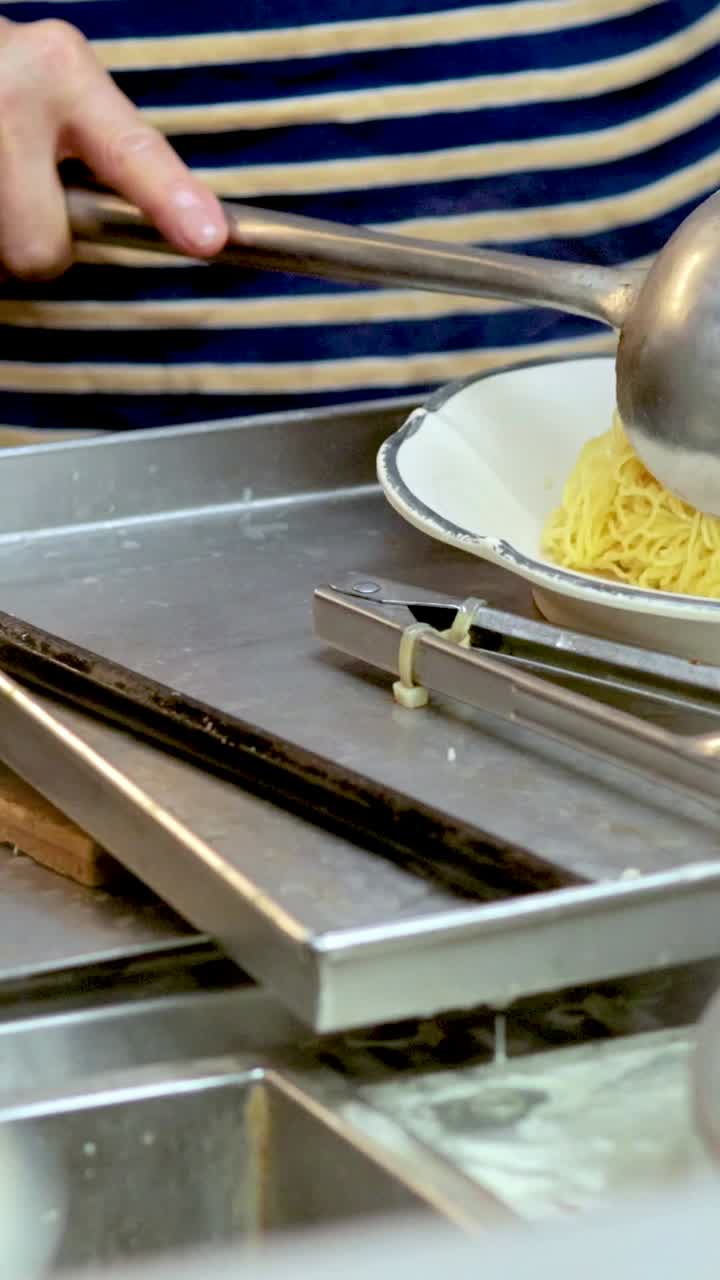 요리사 가 채소 와 고기 어리 를 넣은 누들 수프 를 조립 하고 있다