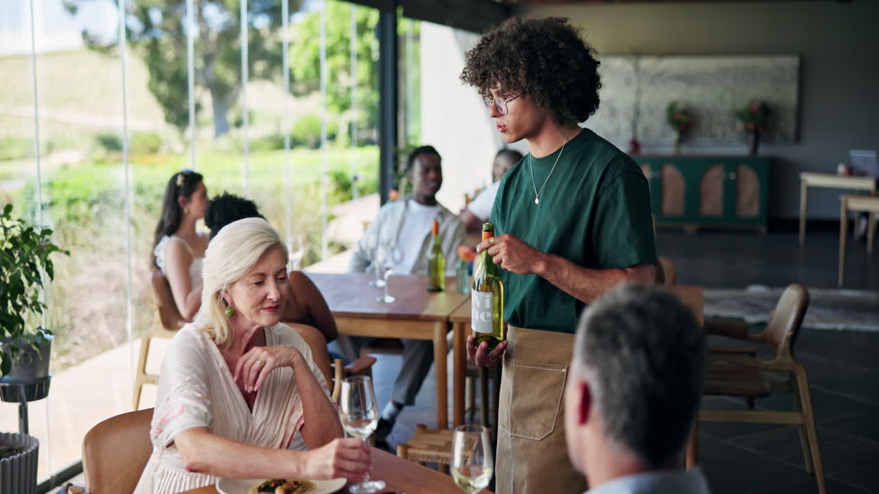 Waiter Serving Wine to a Couple in an Upscale Restaurant