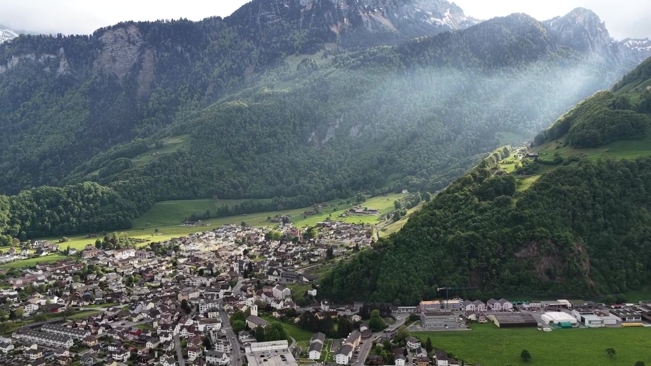 Villaggio di montagna ai piedi delle Alpi svizzere, regione alpina Alpi di Glarona Svizzera, paesaggio aereo ripreso da drone