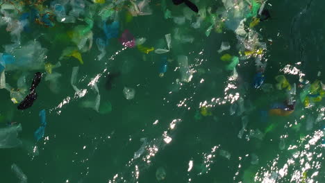 floating plastic rubbish on blue tropical ocean, top down view