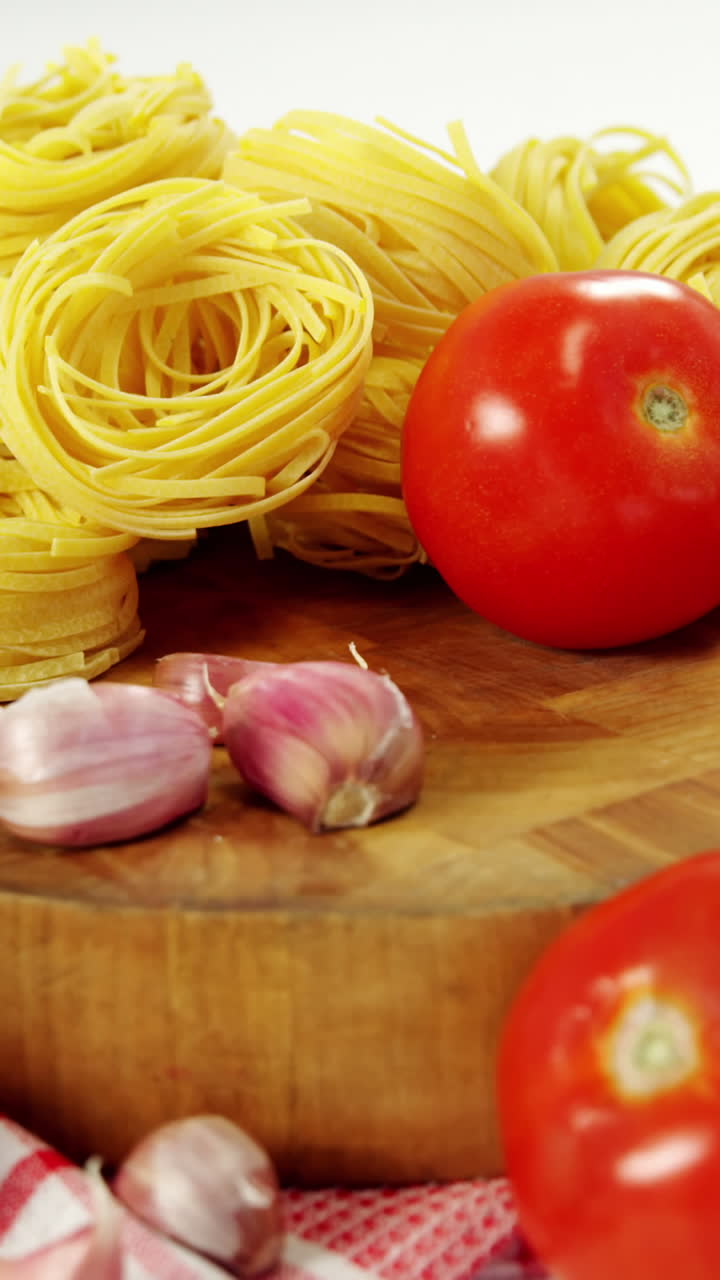 Pomodori e pasta cruda su tagliere
