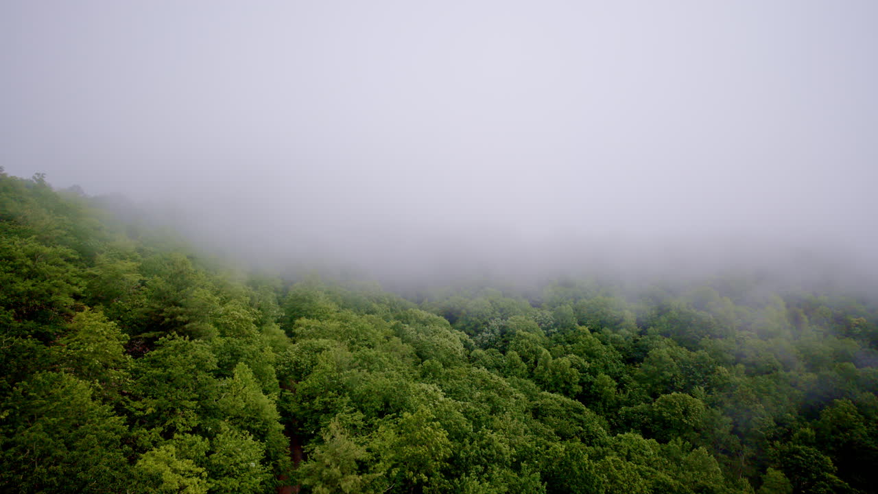 Drone captures aerial view of fog rolling through mountains