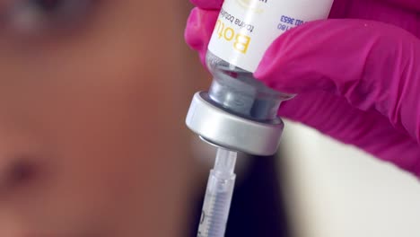 female medical professional filling a syringe with botox - close up