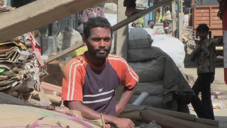 a young man sits and smiles as others work around him