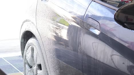 el coche se está lavando con espuma.