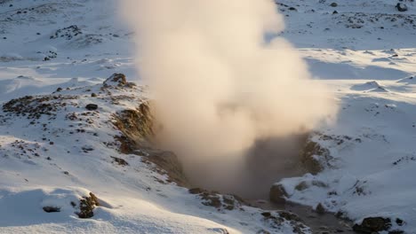 majestic geyser erupts in a snow-covered landscape, creating clouds of steam against the backdrop of an icy terrain, showcasing nature's power and beauty