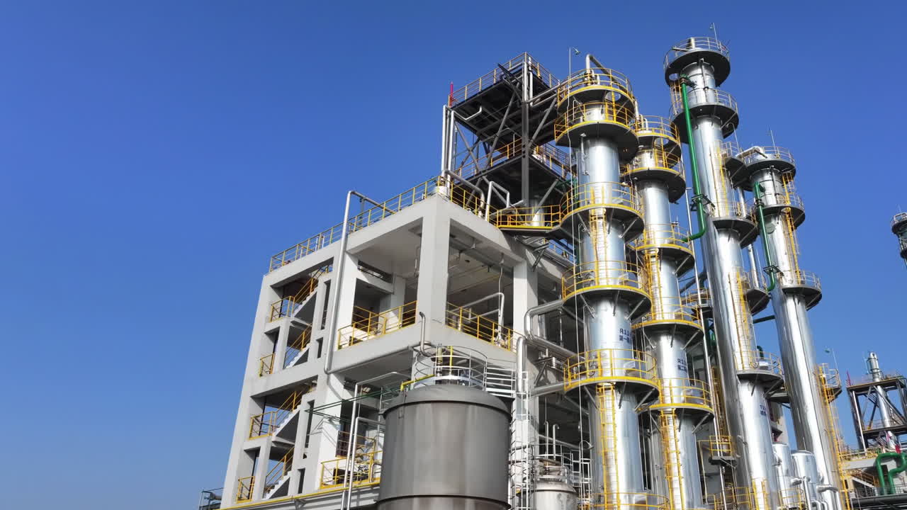 Petrochemical factory industrial storage steel tanks buildings and complex piping equipment in Oil gas refinery industry plant under blue sky