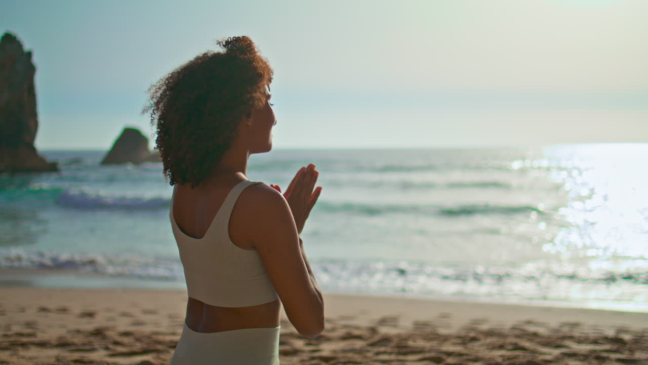 ragazza seduta mani namaste guardando l'alba di mattina da vicino. donna che medita.
