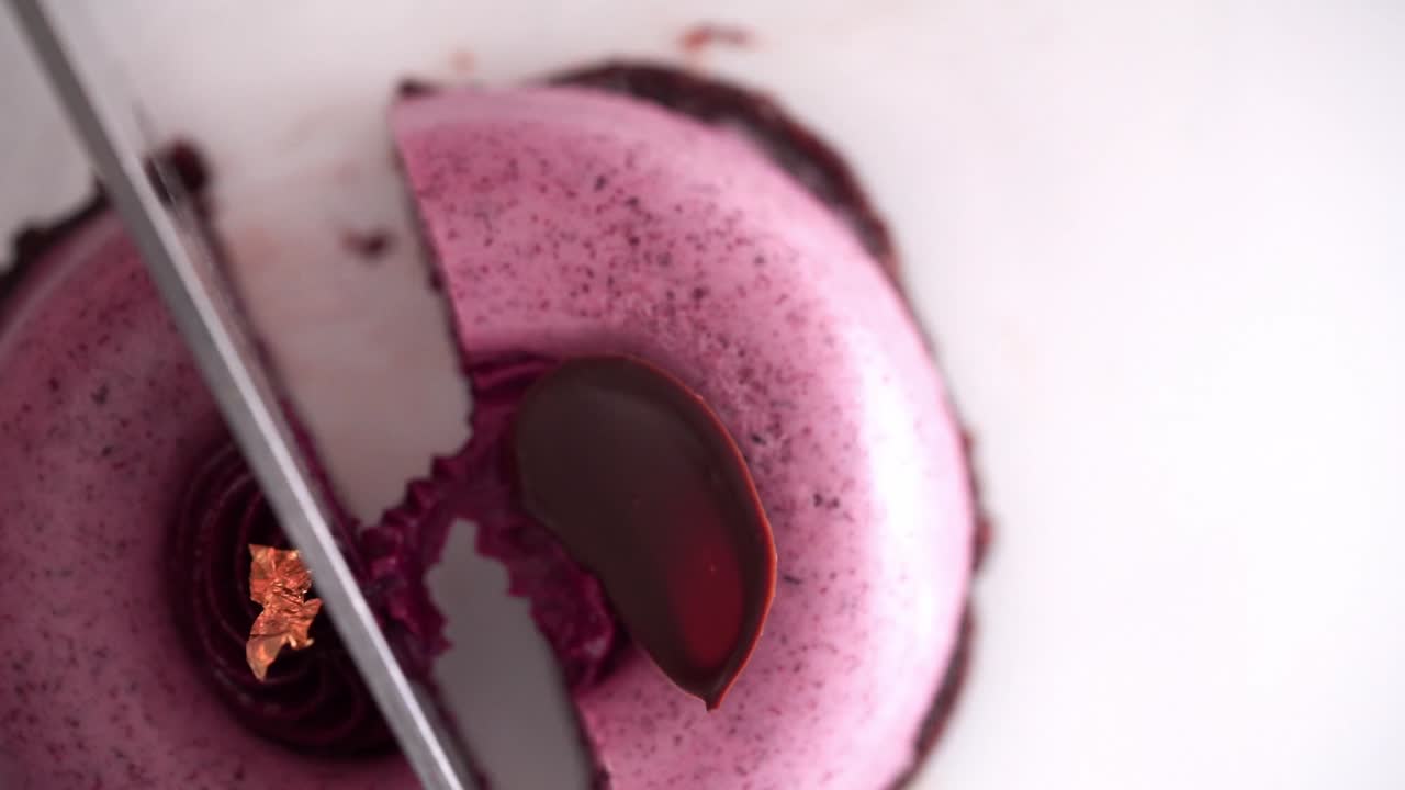 칼로 반으로 자른 작은 분홍색 둥근 베리 케이크