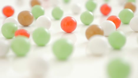 lot of various color bonbons on the white shiny and reflective background 4k 3840x2160 uhd video - mixed color round candies on the white surface 4k 2160p 30fps ultrahd footage