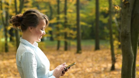 girl with phone in park. young woman speaking on mobile phone in park