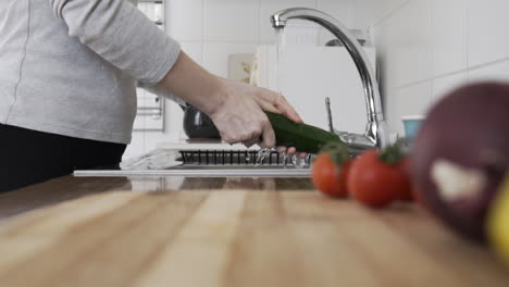 Tiro-Medio-Como-Ama-De-Casa,-Una-Mujer-Lavando-Verduras-En-La-Cocina-En-El-Fregadero