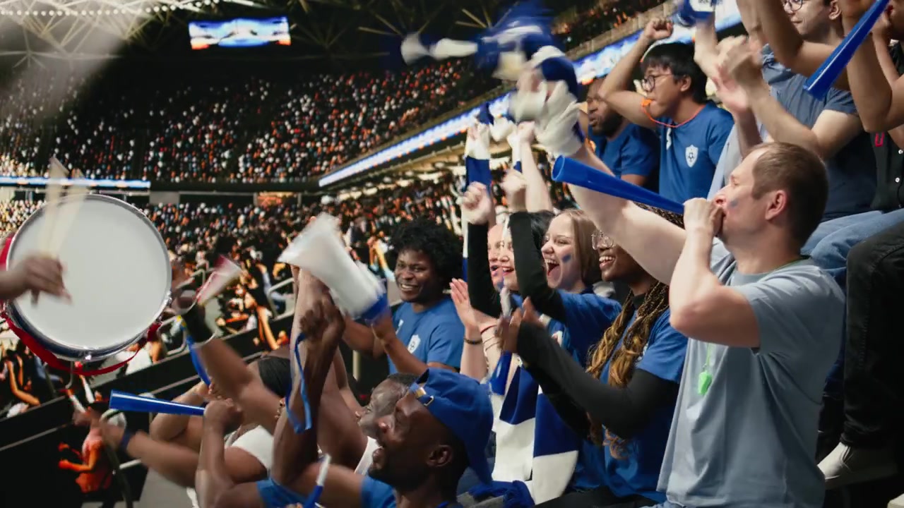 Apasionado capo de fútbol tocando el tambor y dirigiendo a un grupo de aficionados azules.