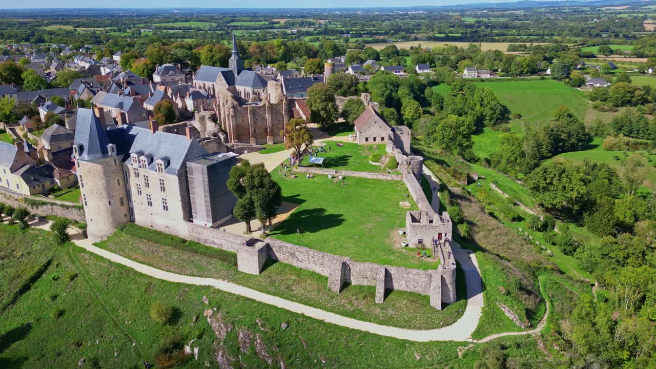 Drone shot panning around the fortified city of Sainte-Suzanne in Mayenne, showing the castle, ramparts and surrounding countryside from above