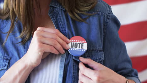 Una-Mujer-Caucásica-De-Mediana-Edad-Coloca-Una-Insignia-De-&quot;voto&quot;-En-Su-Chaqueta-Vaquera