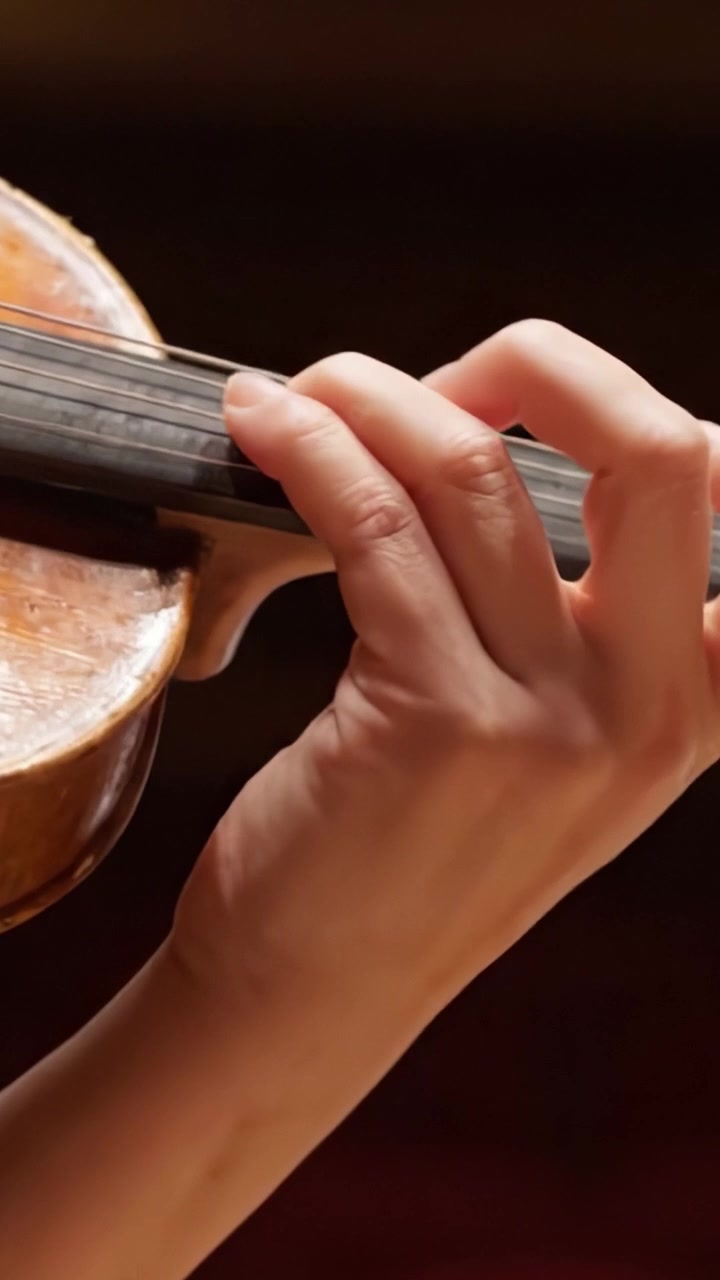 A Close-Up View of a Skilled Musician's Hand Gracefully Playing the Violin, Showcasing the Beautiful Craftsmanship and Artistry of the Instrument in Motion