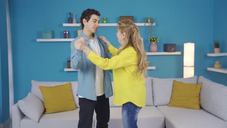 una madre y un hijo felices y alegres bailando en casa.
