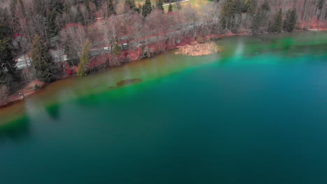 fast aerial approach of the coastline of the lake tegernsee in bavaria with crystal clear water