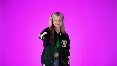 adolescente alegre baila a la música en los auriculares y muestra los pulgares hacia arriba, grabación de estudio