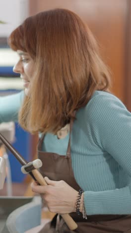 woman crafting jewelry with tools in a workshop