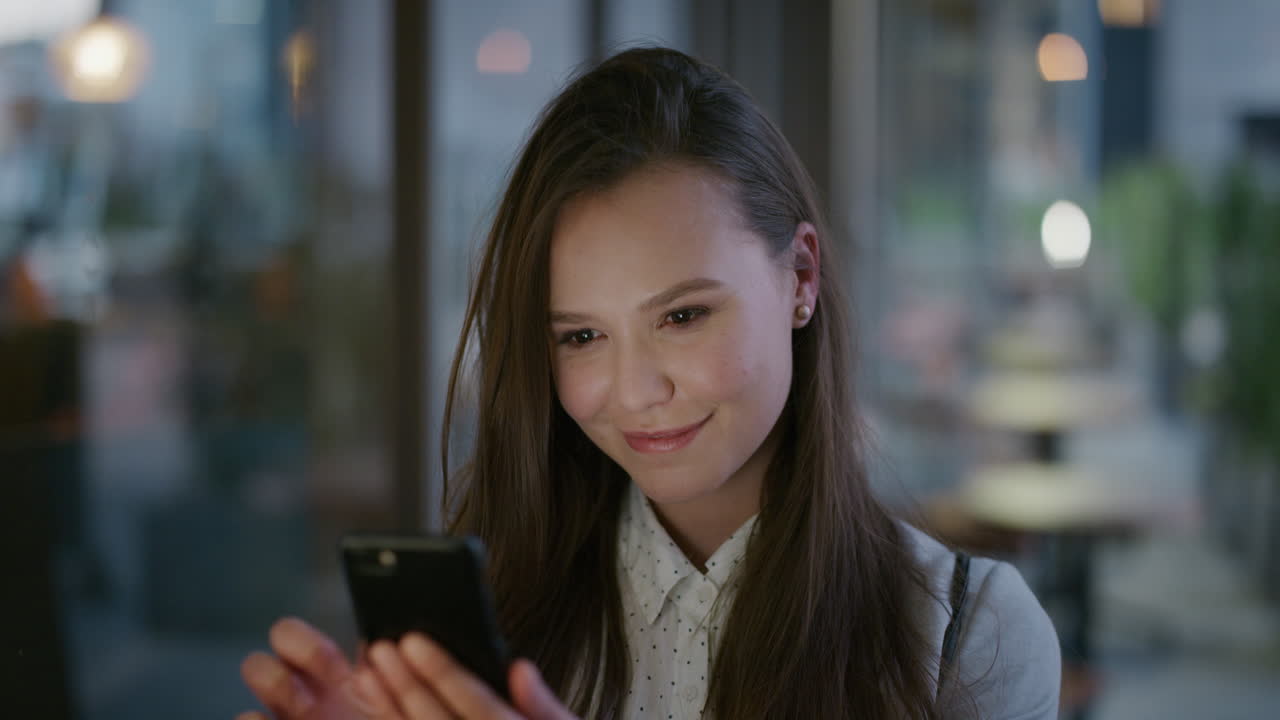 도시 저녁에 스마트폰을 사용하여 온라인 메시지를 검색하고 휴대폰으로 문자 메시지를 보내는 젊은 아름다운 비즈니스 여성의 초상화
