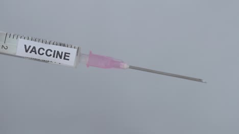 removing cap of syringe needle - covid-19 vaccine - close up