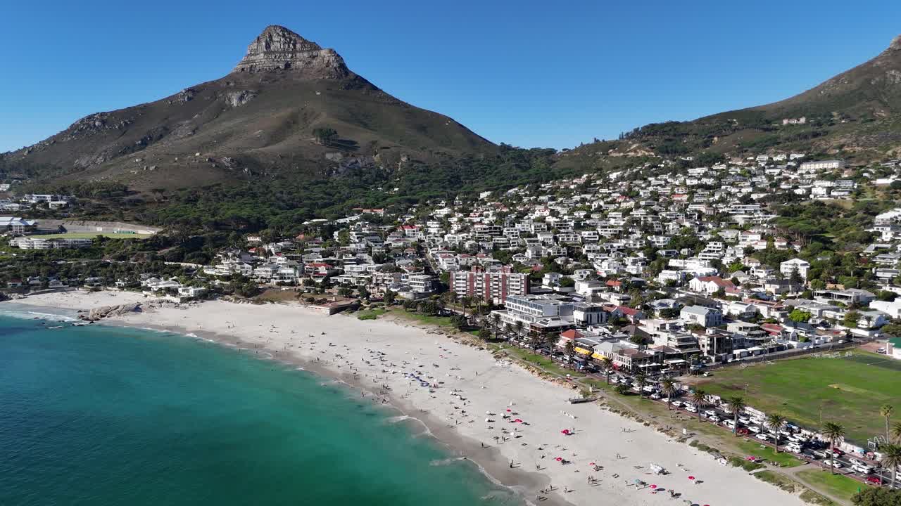 Aerial of Lion’s Head mountain and Camps Bay, Cape Town, South Africa. drone flying high above the coastline with cinematic beach and ocean scenery
