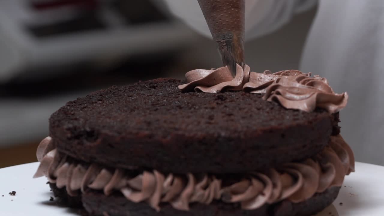 Premium stock video - Wipping cream on second  layer of choccalate cake