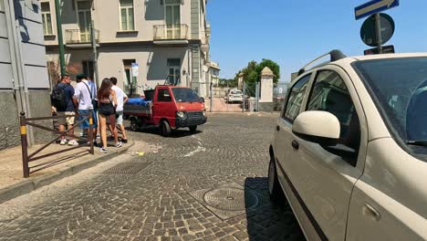 cars and pedestrians on a cobblestone street