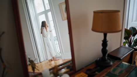 Calm-lady-drinking-tea-home-morning.-Tender-woman-watching-window-at-living-room