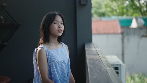 young woman using phone on a balcony