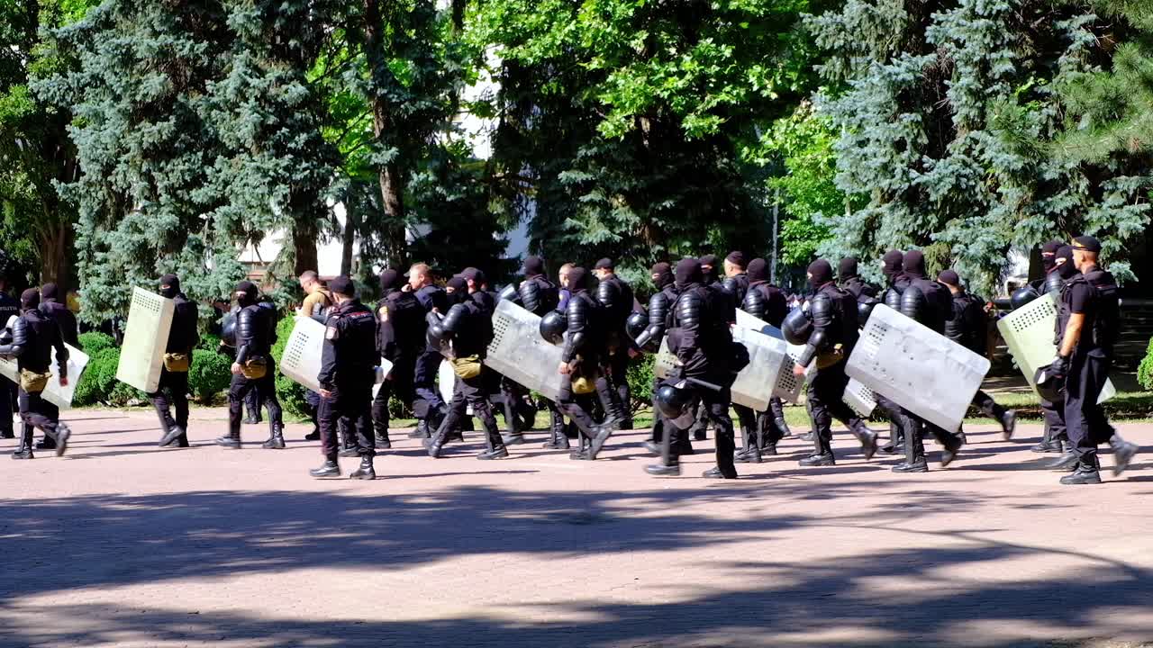 Riot police marching with shields