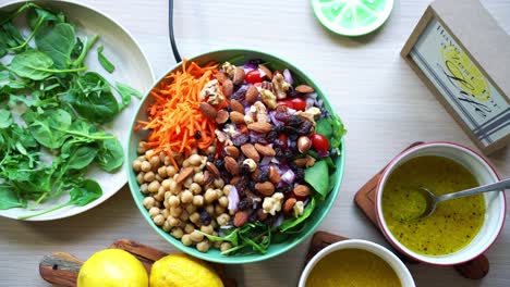 Aerial-view-rotating-making-a-salad-Adding-spinach-to-dish-beets-quinoa-seeds-lemons-and-onions-in-the-scene-tomatoes-and-salad-dressing