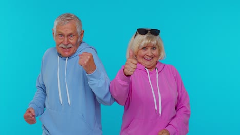 Cheerful-senior-couple-man-woman-grandparents-shouting,-celebrating-success-winning,-goal-achievemen